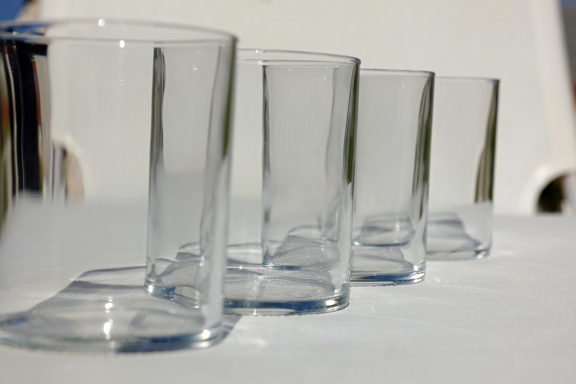 Четверо стаканов. Стаканы. Блестящие стеклянные стаканы. Четыре стакана. Красивые стаканы для воды.