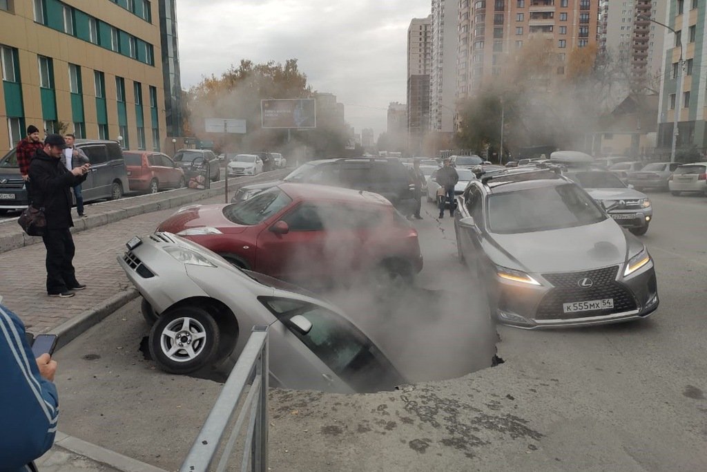 Фото: в Новосибирске три припаркованных автомобиля ушли под землю